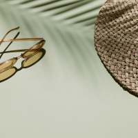 Hat and sunglasses in the shadow of a palm tree near The Current Apartments in Biloxi, Mississippi
