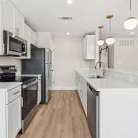 Apartment kitchen with wooden cabinets at Lake Meadows in Garland, Texas