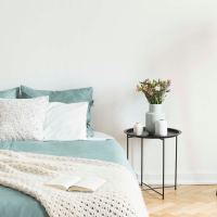 Modern furnishings in a model apartment's primary bedroom at Villas of Brighton in Rochester, New York