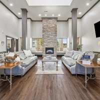 Spacious clubroom with large windows and a modern fireplace at Blue Ridge in Midland, Texas