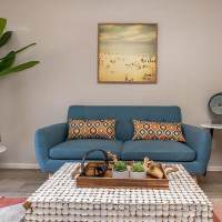 Cozy living room with blue sofa, decorative pillows, and a coffee table with decor at Fairways on Thunderbird in Phoenix, Arizona