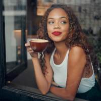 Woman enjoying coffee indoors at August Friendswood in Friendswood, Texas