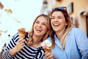 Happy friends eating ice cream near Casa Mediterrania in Colton, California