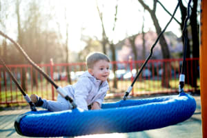 Kid playing in playground near Sierra Gardens in Riverside, California