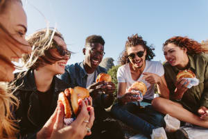 Happy friends having burger near Casa Bella in Victorville, California