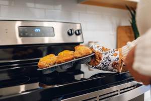 Two women talking over food in their kitchen at The Waters at West Village in Scott, Louisiana