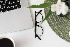 A laptop and glasses on a table at Vista Rose Apartments in Wasilla, Alaska