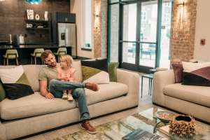 Father along with her daughter sitting on a sofa at The Flats at Ransley in Pensacola, Florida