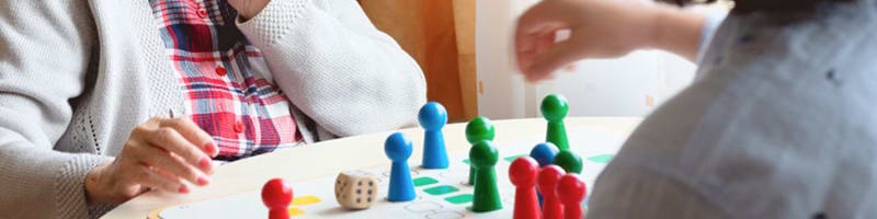 Senior companion and elderly woman share a chess game.