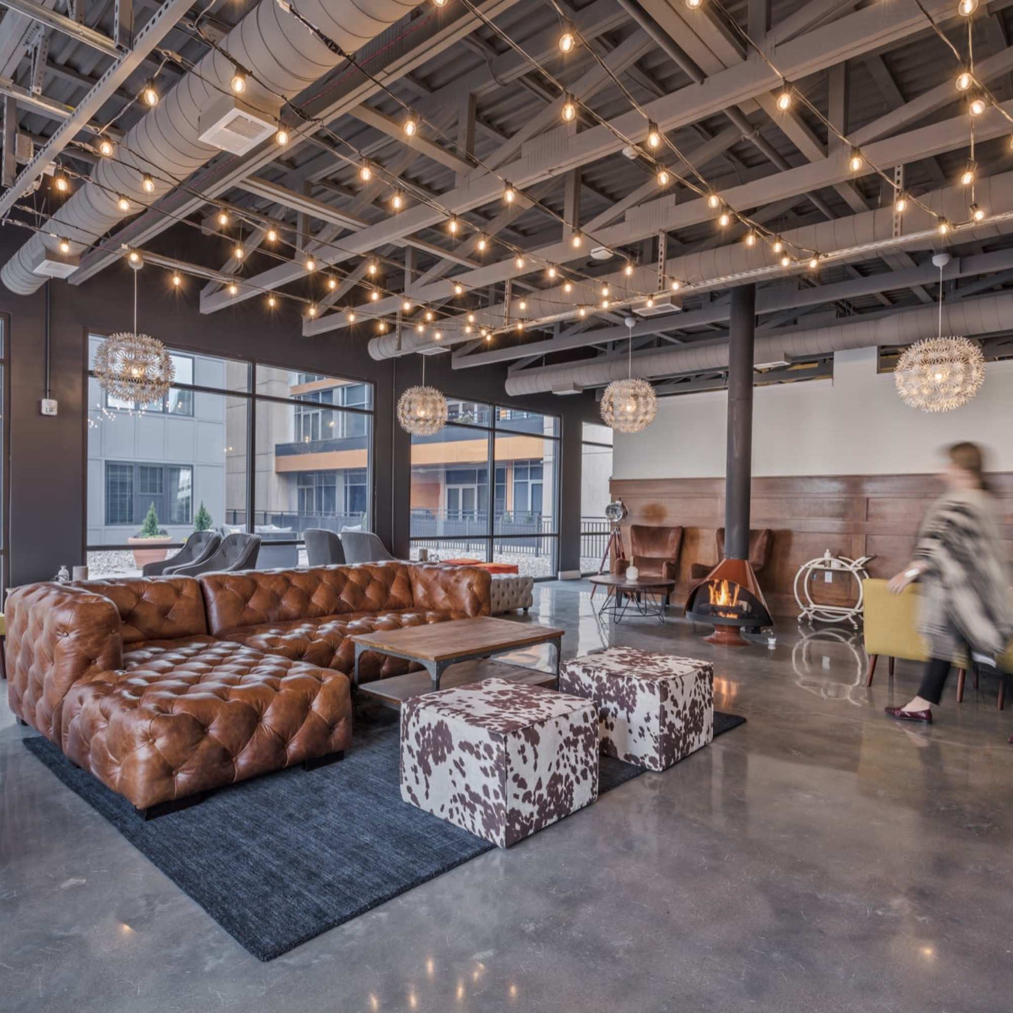 Person walking past a brown leather sofa at 223 E Town in Columbus, Ohio
