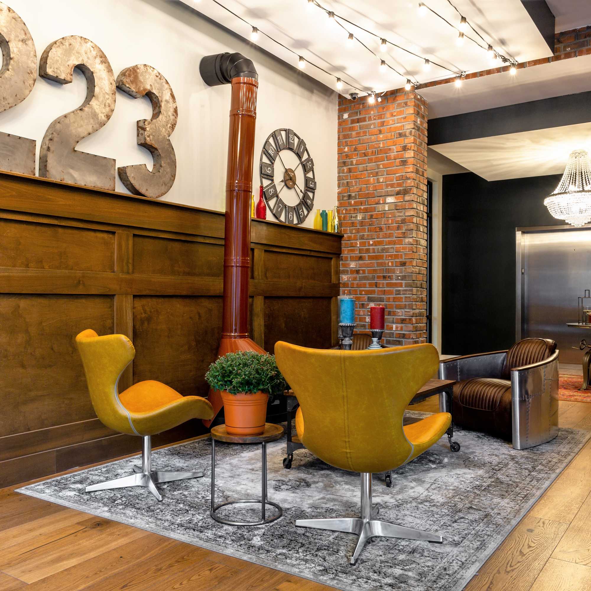 Two yellow chairs with a plant on a table at 223 E Town in Columbus, Ohio