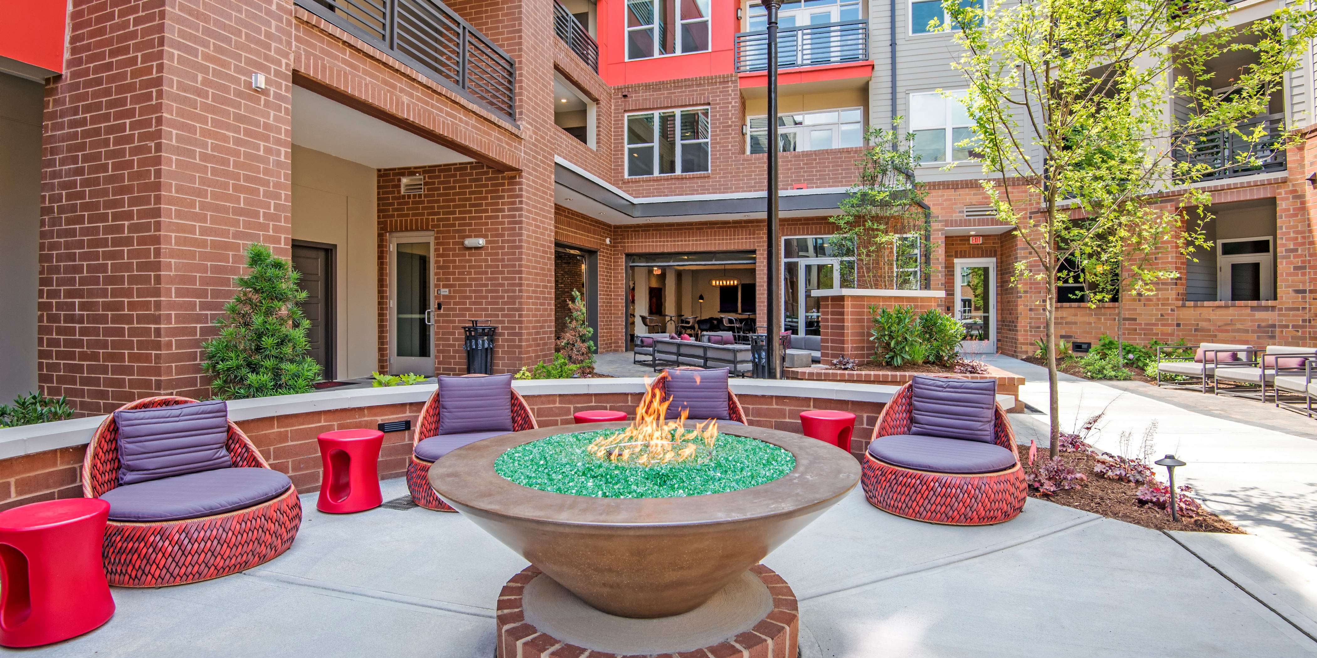 Modern outdoor lounge with large firepit at Mercury NoDa in Charlotte, North Carolina