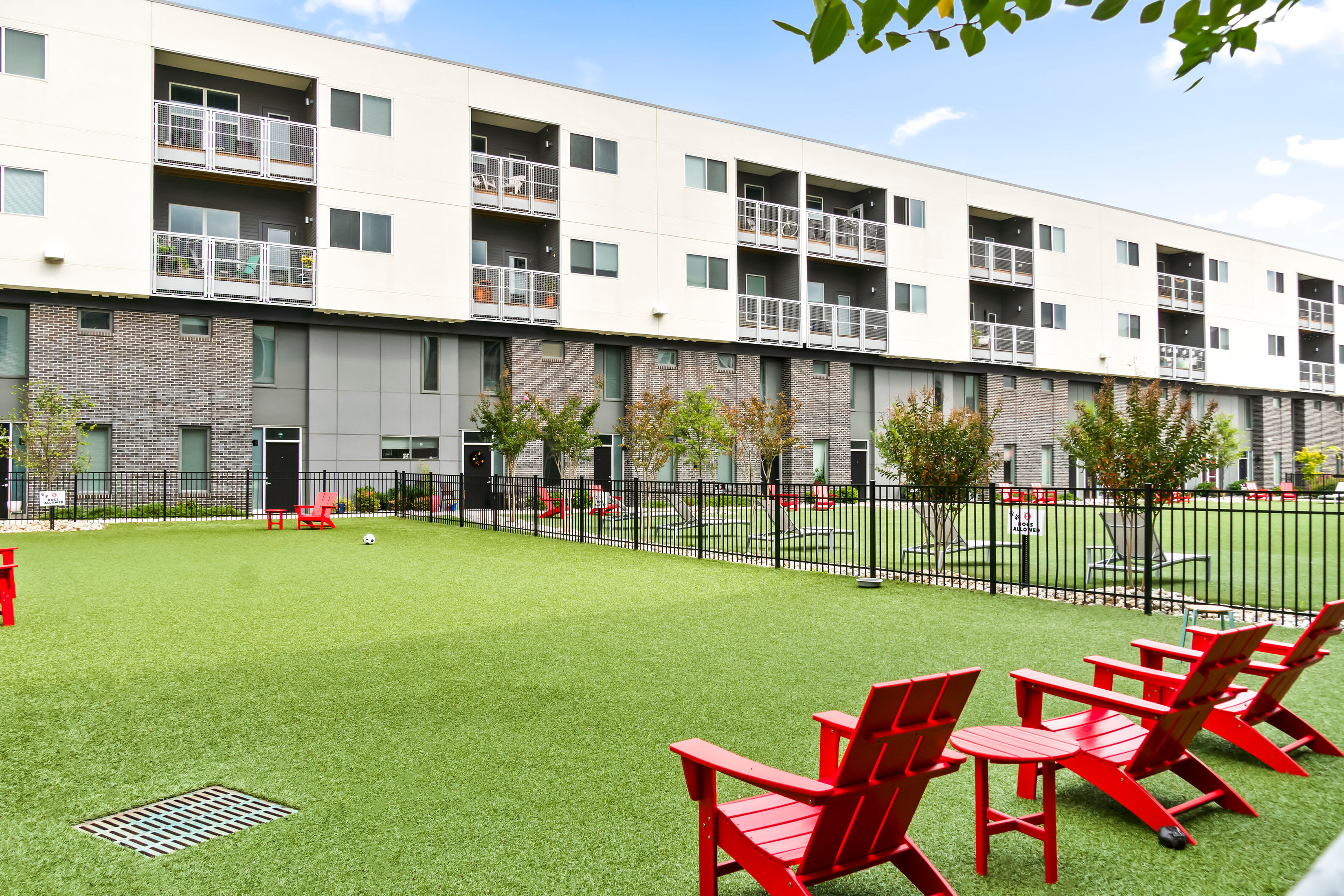 SYMBOL Scott’s Addition exterior overlooking the landscaped courtyard with red Adirondack chairs