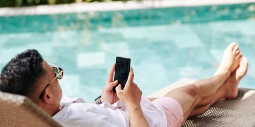 Man relaxing by the pool at Valencia Trace in Orlando, Florida