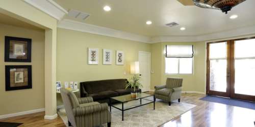 Patio and balcony access through a glass windowed door from an open-layout living room at Countryside Apartments in Poway, California