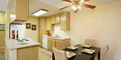 Dining room with close access to fully-equipped kitchen with cabinetry at Countryside Apartments in Poway, California