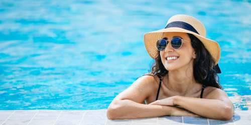 Resident relaxing in a swimming pool at Reidy Creek Apartments in Escondido, California