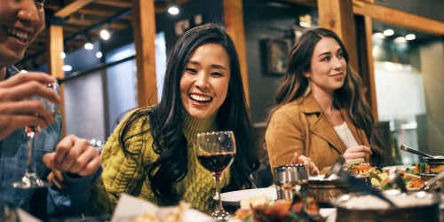 Resident with friends having food and drinks in restaurant near Arlington Gardens in Arlington, Massachusetts