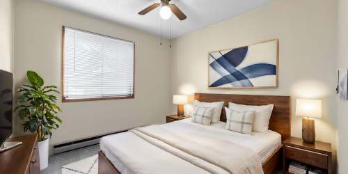Model unit with bed, artwork and modern bed textiles at Eastwood on Grand in West Des Moines, Iowa