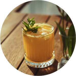 An orange cocktail in a short glass at Romero Apartments in Pensacola, Florida