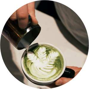 A cup of matcha with a leaf design on top at a cafe near  Romero Apartments in Pensacola, Florida