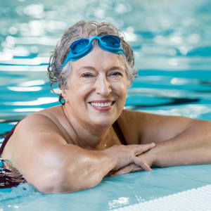 Woman swimming at Avenida Lakewood senior living apartments in Lakewood, Colorado