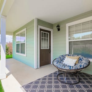Back porch of a residence with a comfy papasan chair at Sunstone Village in Denton, Texas