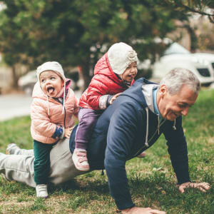 Resident playing with his grandkids outside at Sunstone Village in Denton, Texas.