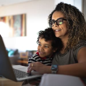 Resident watching a movie with her grandson on a laptop at Round Rock Townhomes in Arlington, Texas