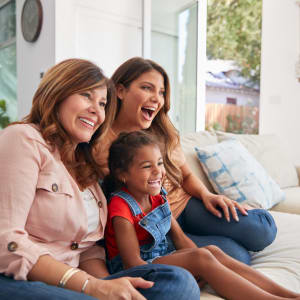 Family having fun sitting on their couch at Round Rock Townhomes in Arlington, Texas
