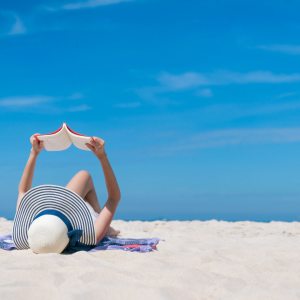 Resident reading a book at the beach in The Grand at Bayfront in Hercules, California