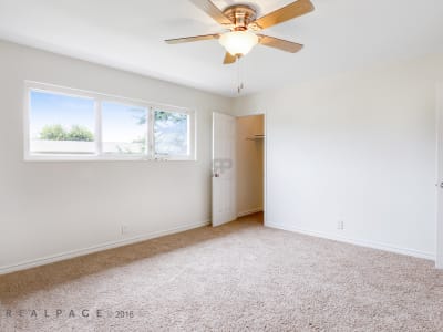 Well-lit bedroom with carpet at Washington Townhomes in San Lorenzo, California