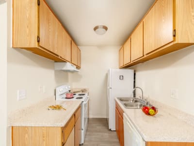 Kitchen with appliances and overhead cabinets at Creekside Village in San Bernardino, California
