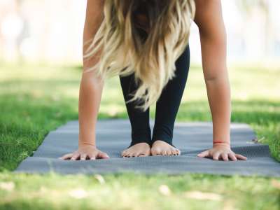 Woman doing yoga outside in the grass at Vienna Woods 
