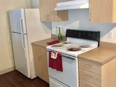 Well equipped kitchen with wooden cabinets at Heron Creek Apartments in Moses Lake, Washington