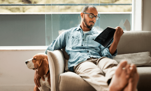Resident reading with his pup at Marshall Apartment Homes in Balch Springs, Texas