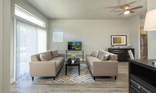 Living room with vinyl plank flooring and a ceiling fan at Octave in Davis, California