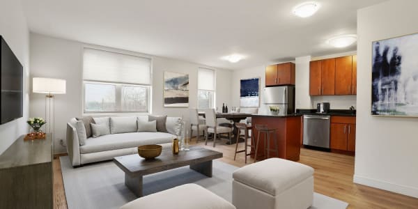 Large living space with wood-style flooring at Camelot Court in Brighton, Massachusetts