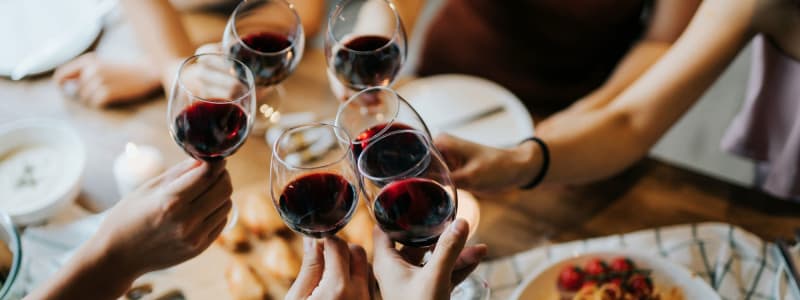 Friends raising their wine glasses to a fun night near Eastgold NYC in New York, New York