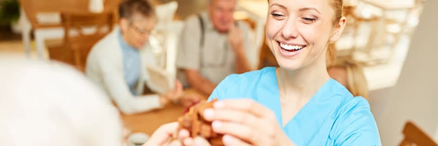 Caregiver smiling with a resident at Wellington Place at Rib Mountain in Wausau, Wisconsin