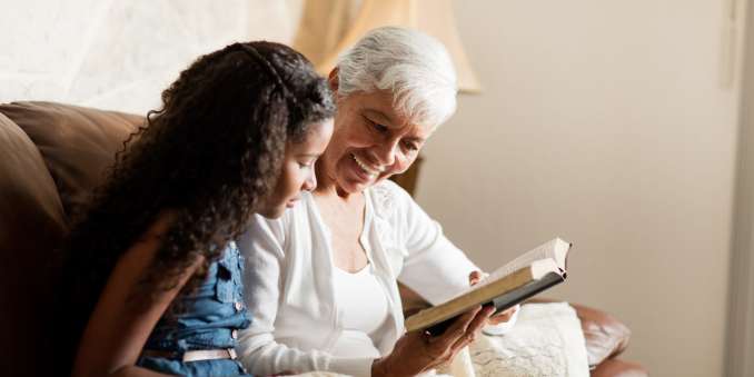 Resident reading with a younger family member at The Barclay at Boynton Beach in Boynton Beach, Florida