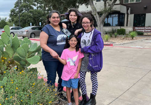 Family outside the entrance to Juniper Creek in Austin, Texas