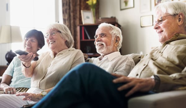 Residents sitting on a couch watching something on tv at Anthology Senior Living in Chicago, Illinois