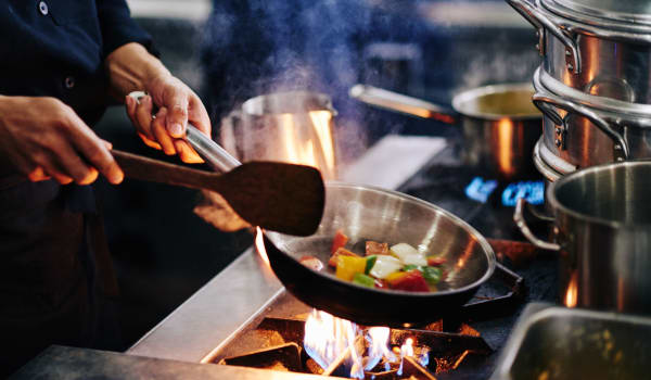 A chef cooking a meal over a flame at Amaran Senior Living in Albuquerque, New Mexico