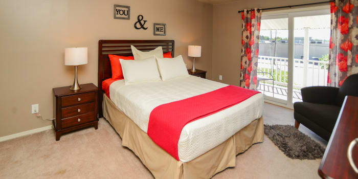 Red and white colors featured prominently in model bedroom at Greentree Village Townhomes in Lebanon, PA