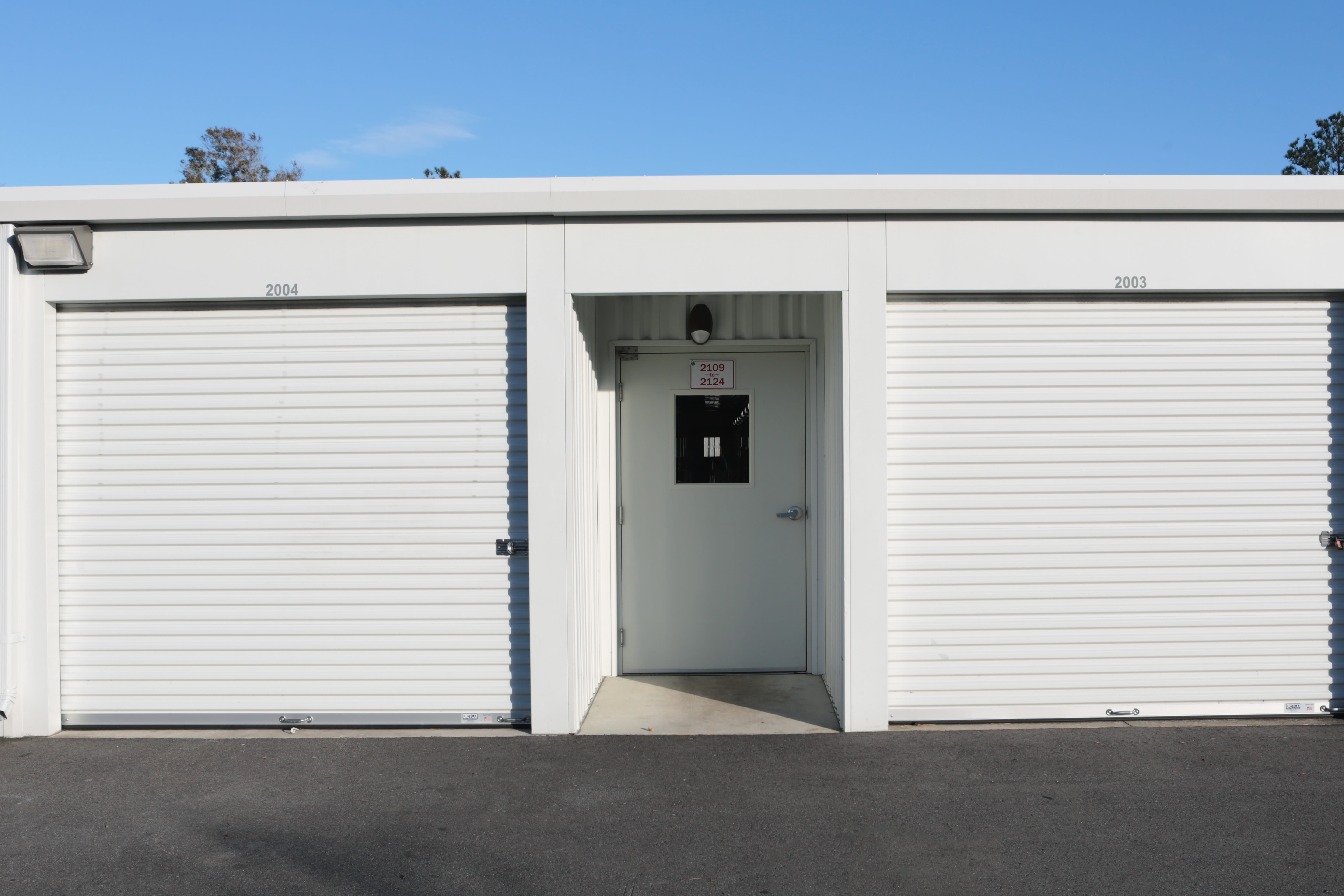 Storage units with white doors at Midgard Self Storage in Wilmington, North Carolina
