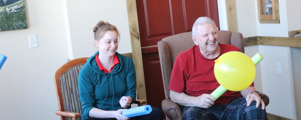 Resident and caregiver playing balloon game at The Springs at Whitefish in Whitefish, Montana