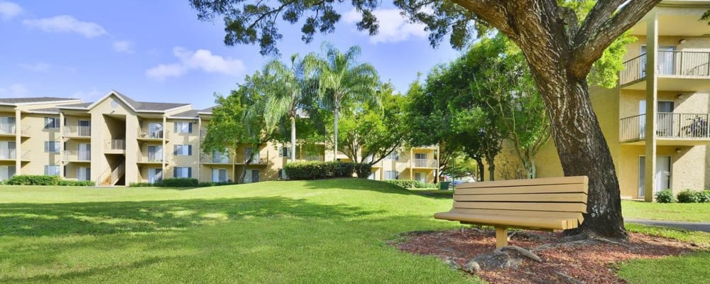 A manicured lawn and park bench at Palmetto Place in Miami, Florida