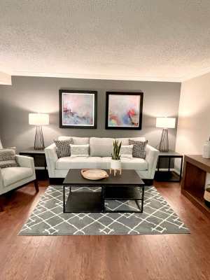 Living room with hard wood-style flooring and quality furniture at The Abbey at Briargrove Park in Houston, Texas