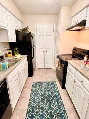Galley-style kitchen with faux granite countertops at The Abbey at Medical Center in San Antonio, Texas